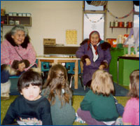 Two elderly women speaking to an elementary school class